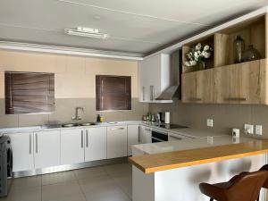 a kitchen with white cabinets and a sink at The Onyx Luxury Apartment in Windhoek