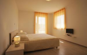 a bedroom with a large bed and a television at Spacious apartment sleeps 4 by the beach in Medulin