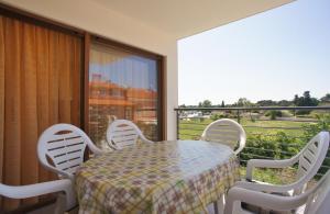 a table and chairs on a balcony with a view at Spacious apartment sleeps 4 by the beach in Medulin