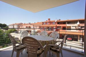 a table and chairs on a balcony with a view at Spacious apartment sleeps 4 by the beach in Medulin