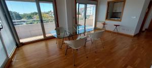 a glass table and chairs in a room with a balcony at Precioso apartamento, espectaculares vistas. in Cangas de Morrazo +41 photos