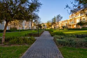 a brick path in a park next to a building at Appartement Taghazout Bay in Taghazout