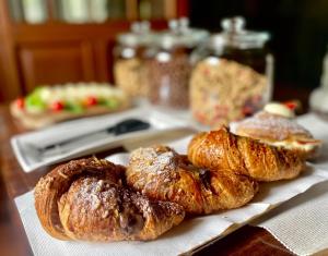 three croissants sitting on a plate on a table at Agriturismo con piscina immerso nella natura La Bisa in Trecenta