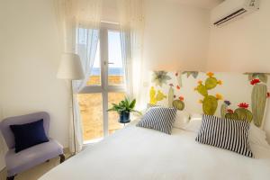 a bedroom with a white bed and a blue chair at Torre dei Pirati in Letojanni