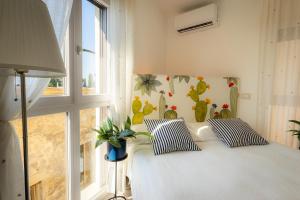 a bedroom with a bed with two pillows and a window at Torre dei Pirati in Letojanni