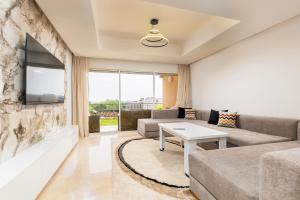 a living room with a couch and a tv at Appartement Taghazout Bay in Taghazout