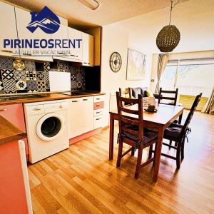 a kitchen and dining room with a table and chairs at Apartamentos Pirineos Rent in Candanchú