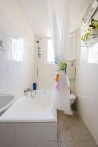 a bathroom with a tub and a toilet with a shower curtain at Charming 2 BR Apt By The Foot Of The Bahai Temple in Haifa