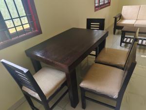 a wooden table with two chairs and a table and a table and chairs at Ecstasy Homestay Puducherry in Pondicherry +12 photos