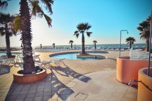 a resort with a pool and palm trees and the ocean at Blue Marine Village in Rodi Garganico