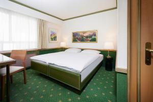 ein Hotelzimmer mit Bett, Schreibtisch und Stuhl in der Unterkunft Hotel Arlette beim Hauptbahnhof in Zürich