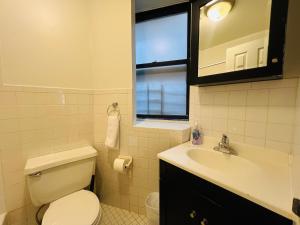 a bathroom with a toilet and a sink and a mirror at The Manhattan on 48th in New York