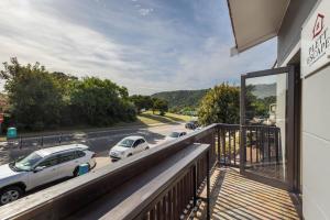a balcony of a building with cars parked on the street at Plett Escape - Central & Walk to the Beach in Plettenberg Bay +28 photos