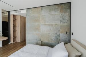 a bedroom with a bed and a stone wall at Villa Alma Nova in Laktaši +48 photos