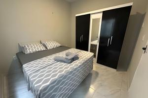 a bedroom with a bed with a blue towel on it at Completa Perfeita para Turismo de Negócios e Lazer por Will Stay in Maracanaú