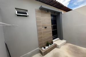 a white building with a window and some plants at Completa Perfeita para Turismo de Negócios e Lazer por Will Stay in Maracanaú
