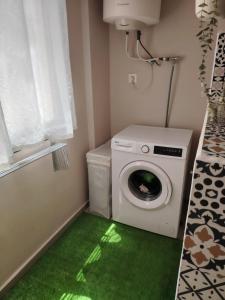 a laundry room with a washing machine and a green floor at Chambre très propre avec salle de bain privée - 5 min airport casablanca in Nouaseur