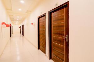 a corridor with wooden doors in a hallway at Hotel O KAILASHA INN in Hasanganj