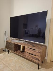 uma grande televisão de ecrã plano num centro de entretenimento em madeira em Helen's Eden em Quios