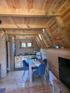 - une salle à manger et une cuisine dans une cabane en rondins avec une table et des chaises dans l'établissement Cottage forest hill 2, à Žabljak