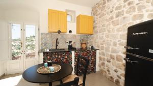 a kitchen with a table and a stone wall at Casa Cucunci in Modica