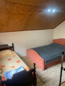 a bedroom with two beds and a wooden ceiling at Stan Travnik in Travnik