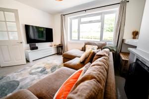 a living room with two couches and a tv at Cliveden Garden Cottage sleeps 6 - With Hot Tub, Parking, in Taplow - next to Cliveden National Park in Maidenhead