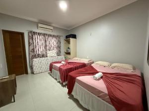 a room with two beds and a chair in it at Nossa Casa de férias em Alter do Chão in Alter do Chao +9 photos