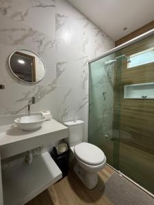 a bathroom with a toilet and a sink and a shower at Nossa Casa de férias em Alter do Chão in Alter do Chao