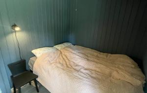 a small bedroom with a bed and a chair at Holmsjøhytta in Sjørbotn
