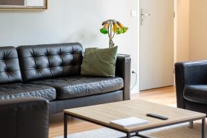 a living room with a leather couch and a coffee table at L'Astrolabe - superbe appartement vue Cathédrale in Rouen +19 photos