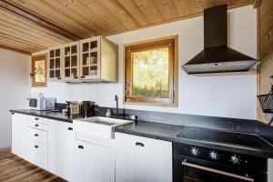 a kitchen with white cabinets and a sink and a window at Chalet Sophie - Proche station de ski in Les Angles +12 photos