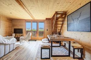 a log cabin living room with a table and a staircase at Chalet Sophie - Proche station de ski in Les Angles
