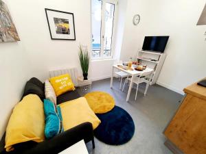 un soggiorno con un divano e un tavolo di Le binic - proche gare et centre a Saint-Brieuc