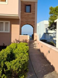 uma passarela que leva a um edifício com um arco em Helen's Eden em Quios