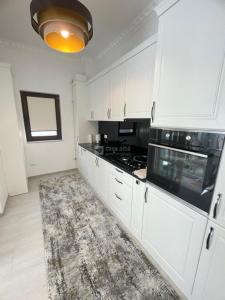 a kitchen with white cabinets and a stove top oven at Vila Premium Iasi in Iaşi