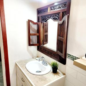 a bathroom with a sink and a mirror at Maison 79 in Soufrière +25 photos