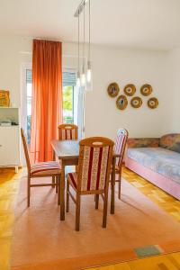 a dining room with a table and chairs and a couch at Million Star Apartment in Budva