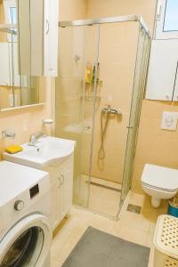 a bathroom with a shower and a washing machine at Million Star Apartment in Budva +11 photos