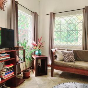 a living room with a couch and two windows at Maison 79 in Soufrière