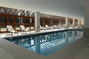 Vista Azul Apart - Vista Mata Atlântica في بيدرا أزول: حمام سباحة مع كراسي ومبنى