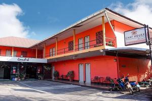 an orange building with motorcycles parked in front of it at Chat House Chiang Rai in Chiang Rai