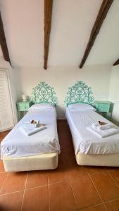 two beds sitting next to each other in a bedroom at Villa Degli Artisti in Cugnana +10 photos