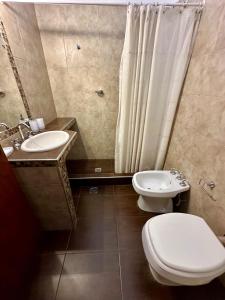 a bathroom with a toilet and a sink and a shower at Hermosa Casa en el Centro, con Cochera in Villa Carlos Paz +5 photos