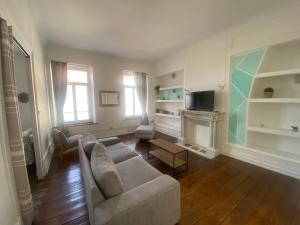 a living room with a couch and a fireplace at Appart au cœur du dernier sou in Boulogne-sur-Mer