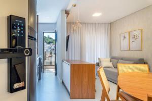 Sunrise Residence في بومبينهاس: مطبخ وغرفة معيشة مع أريكة وطاولة