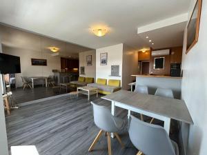 a room with a table and chairs and a kitchen at Bel appartement Vue Mer Climatisé à Biarritz in Biarritz