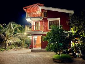 a red house with a balcony on top of it at Shlok Villa in Bāmangaon
