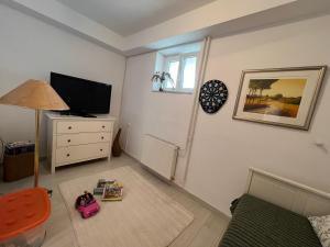 a living room with a couch and a tv and a window at IDa House in Sveti Ivan Zelina
