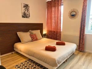 a bedroom with a bed with two pillows on it at L'Horizon Bleu - Appartement 4 chambres avec cour au centre Bourbourg in Bourbourg
